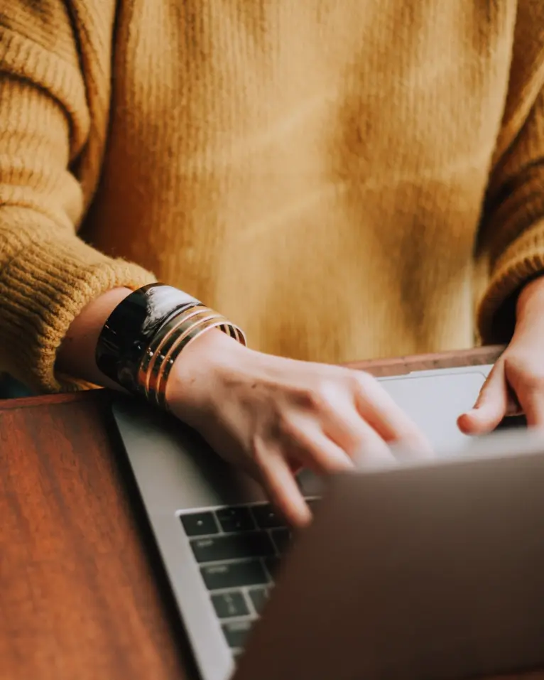 Young and confident person typing on a Apple Macbook for educational purposes. Contemporary style of consulting and investment in educational sector.